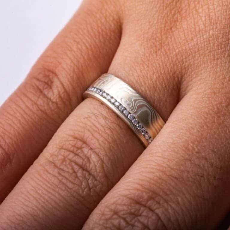 classically stylish mokume gane wedding ring in woodgrain pattern, with small diamonds set in a line going all the way around the ring