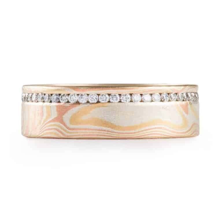 classically stylish mokume gane wedding ring in woodgrain pattern, with small diamonds set in a line going all the way around the ring