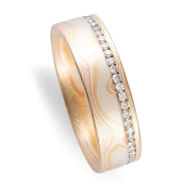 classically stylish mokume gane wedding ring in woodgrain pattern, with small diamonds set in a line going all the way around the ring