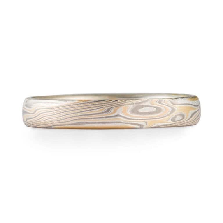 Mokume gane band made in Arn Krebs Flare palette. The Flare palette consists of 14kt Yellow Gold, Palladium, and Sterling Silver. Ring has a low dome profile and smooth finish