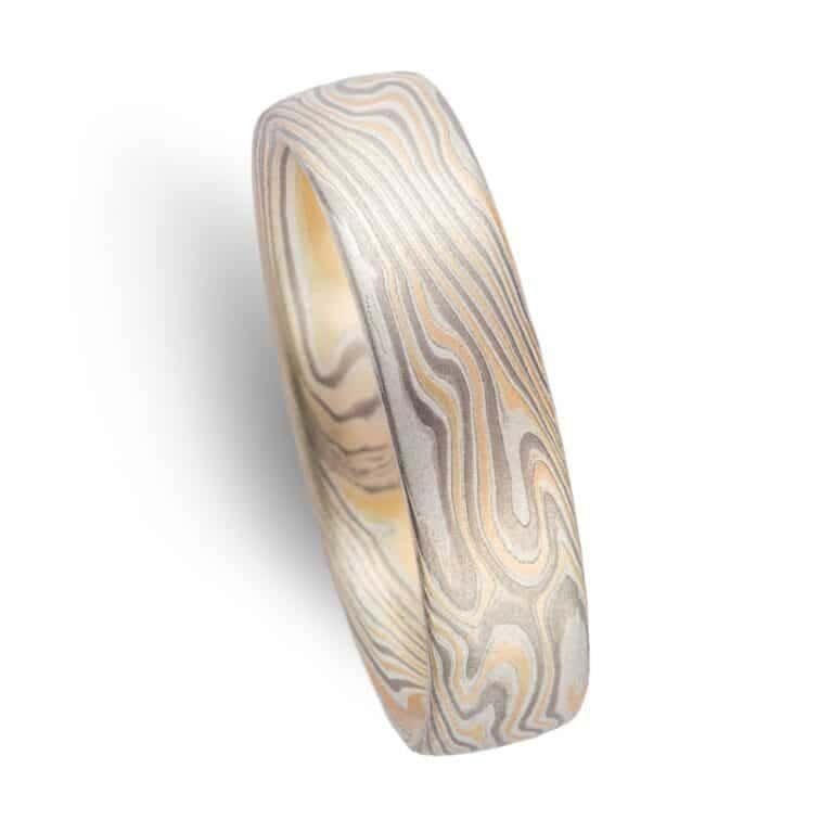 twisted pattern mokume gane ring with smooth surface, made with yellow gold, palladium and sterling silver