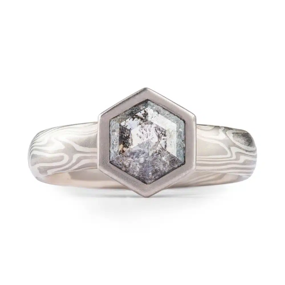 Mokume gane patterned engagement ring with a salt and pepper hexagon shaped diamond.