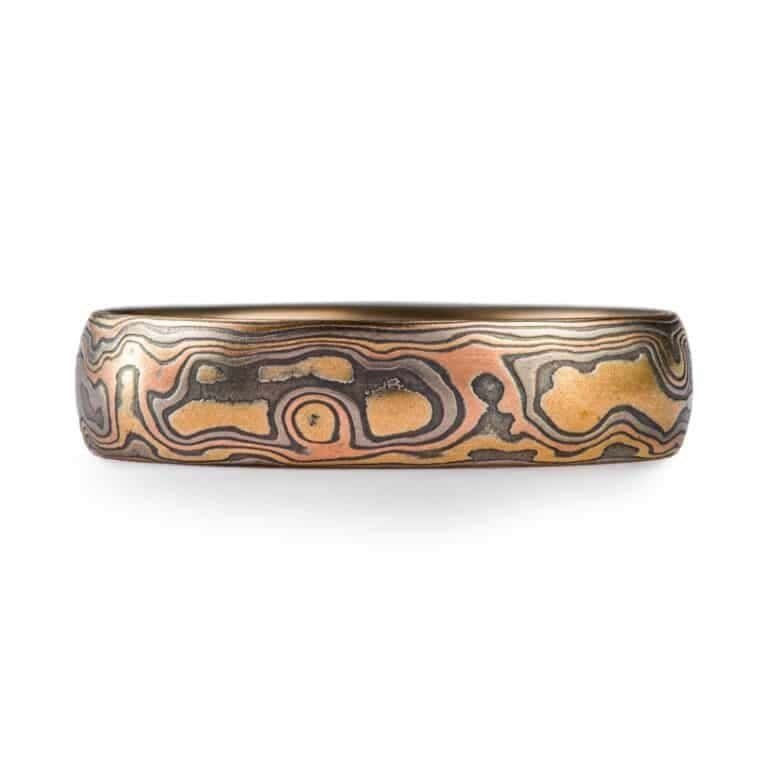 Mokume gane ring arn krebs, wedding band or ring, woodgrain pattern and firestorm palette, firestorm metal combination is red gold palladium silver and yellow gold, yellow gold is most prominent in this ring