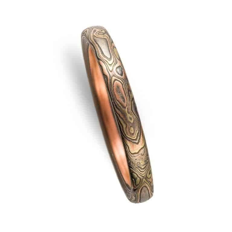 narrow mokume gane band in mixed metals with woodgrain style pattern