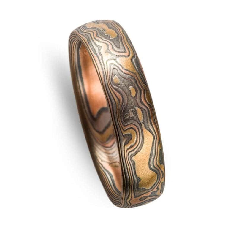 Mokume gane ring arn krebs, wedding band or ring, woodgrain pattern and firestorm palette, firestorm metal combination is red gold palladium silver and yellow gold, yellow gold is most prominent in this ring