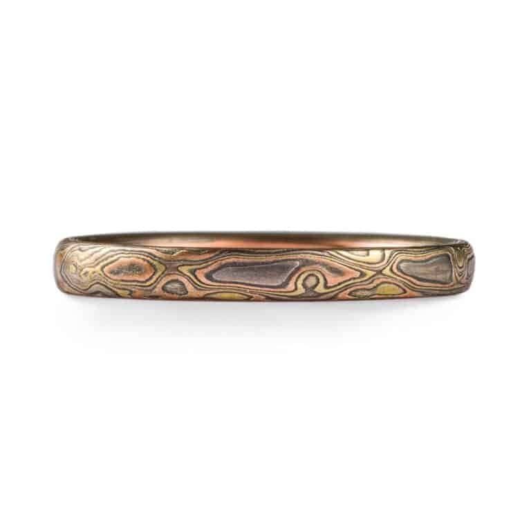 narrow mokume gane band in mixed metals with woodgrain style pattern