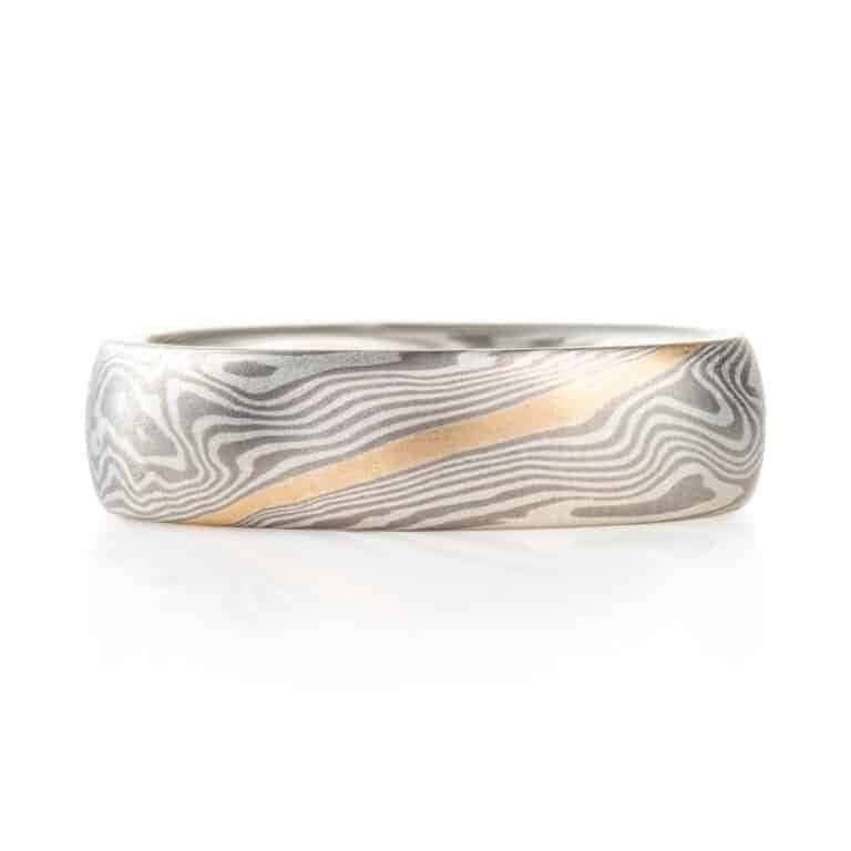 mokume gane band with a flush set salt and pepper diamond and an added yellow gold stratum layer