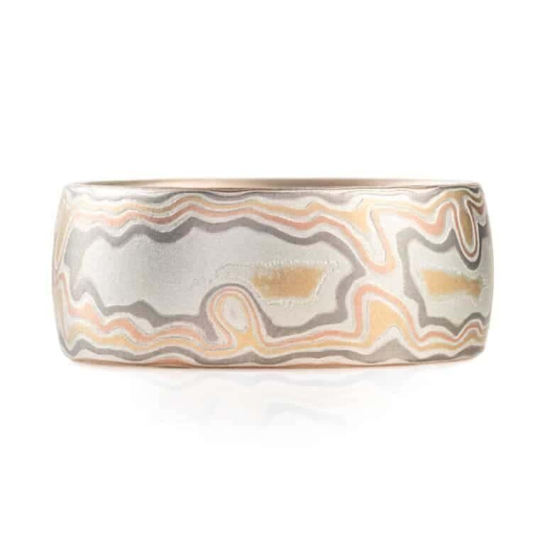 wide woodgrain style patterned ring in a light color palette, slightly domed profile