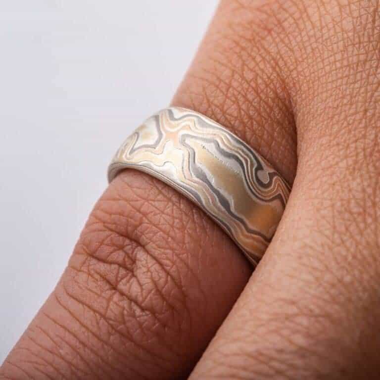 wide woodgrain style patterned ring in a light color palette, slightly domed profile