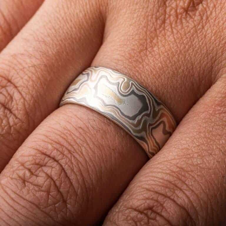 wide woodgrain style patterned ring in a light color palette, slightly domed profile