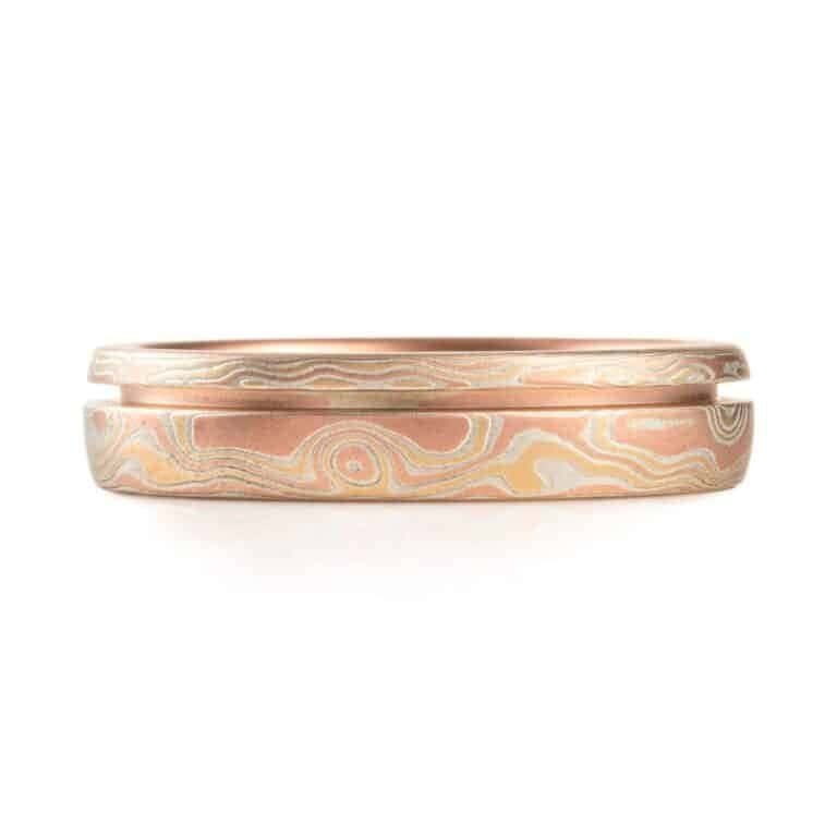 red gold mokume gane ring with a unique inset line, a narrow channel carved into the ring going all the way around, not quite centered, off to one edge