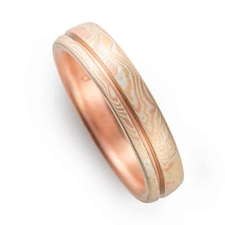 red gold mokume gane ring with a unique inset line, a narrow channel carved into the ring going all the way around, not quite centered, off to one edge