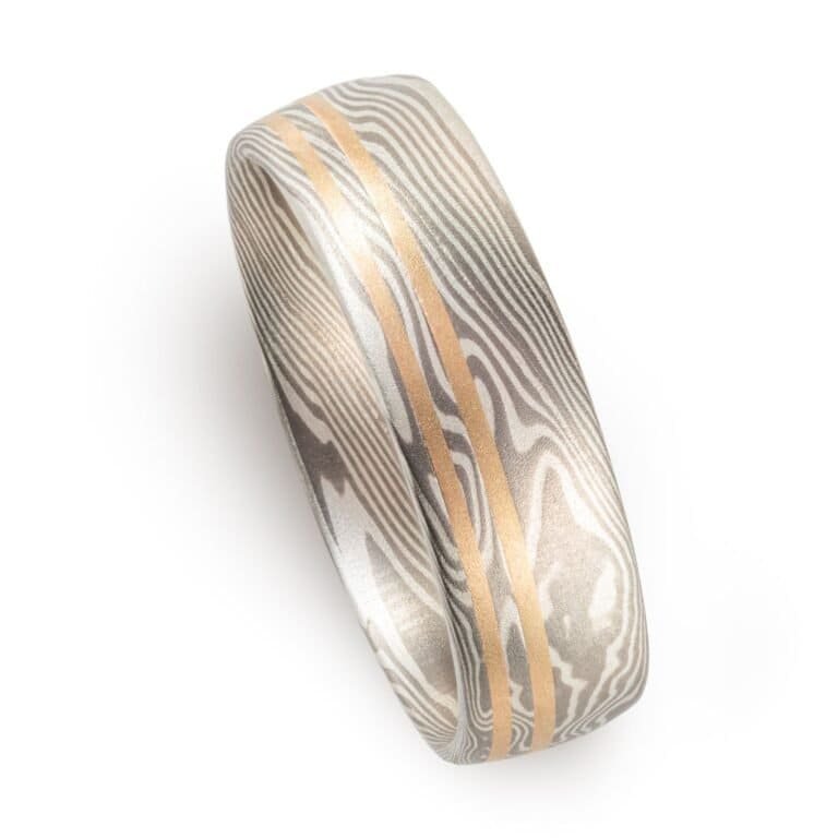 mokume gane silvery ring with two yellow gold lines running perfectly parallel around the band