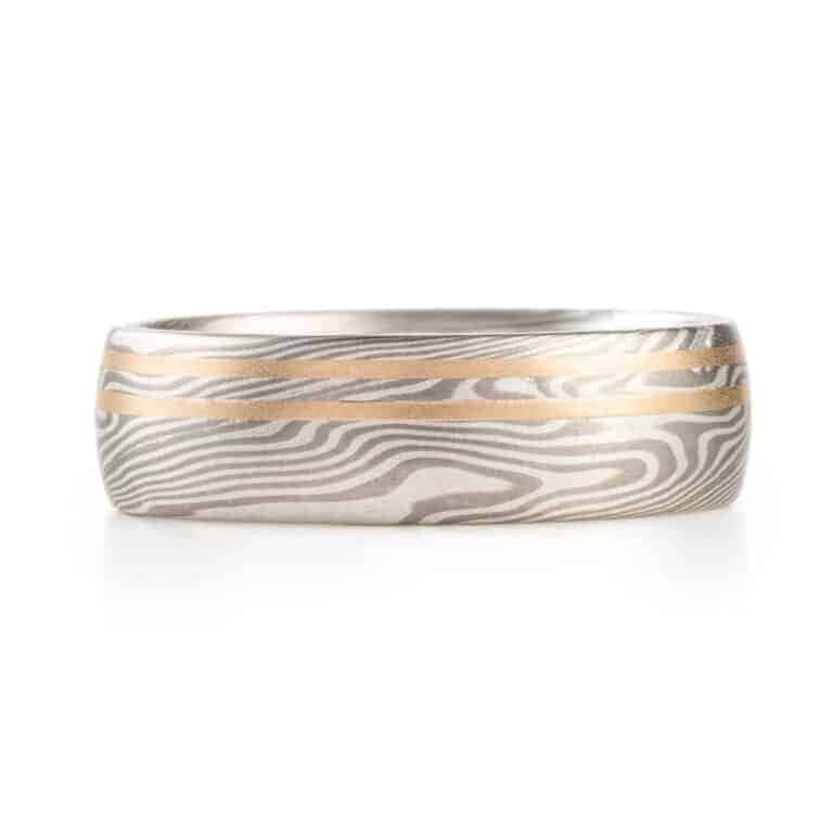 mokume gane silvery ring with two yellow gold lines running perfectly parallel around the band
