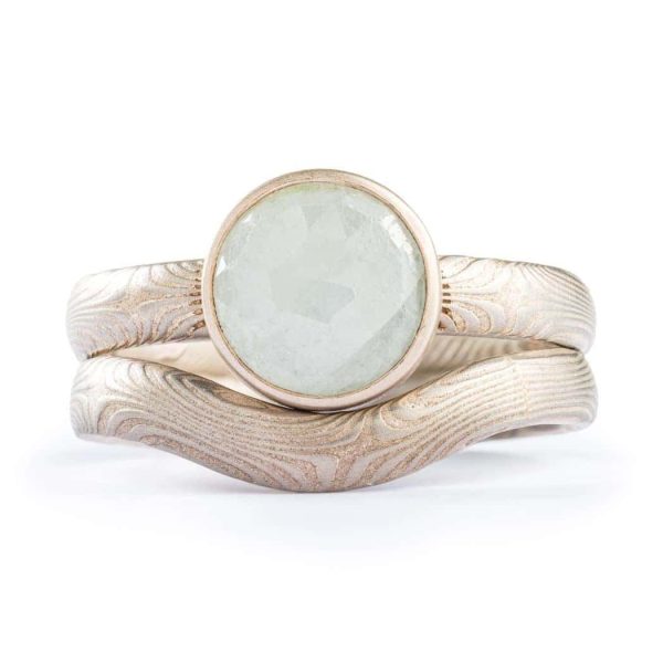 Mokume gane engagement ring with bezel set moonstone bezel setting. 14K white gold palladium sterling silver, with a matching contoured band that curves around the stone