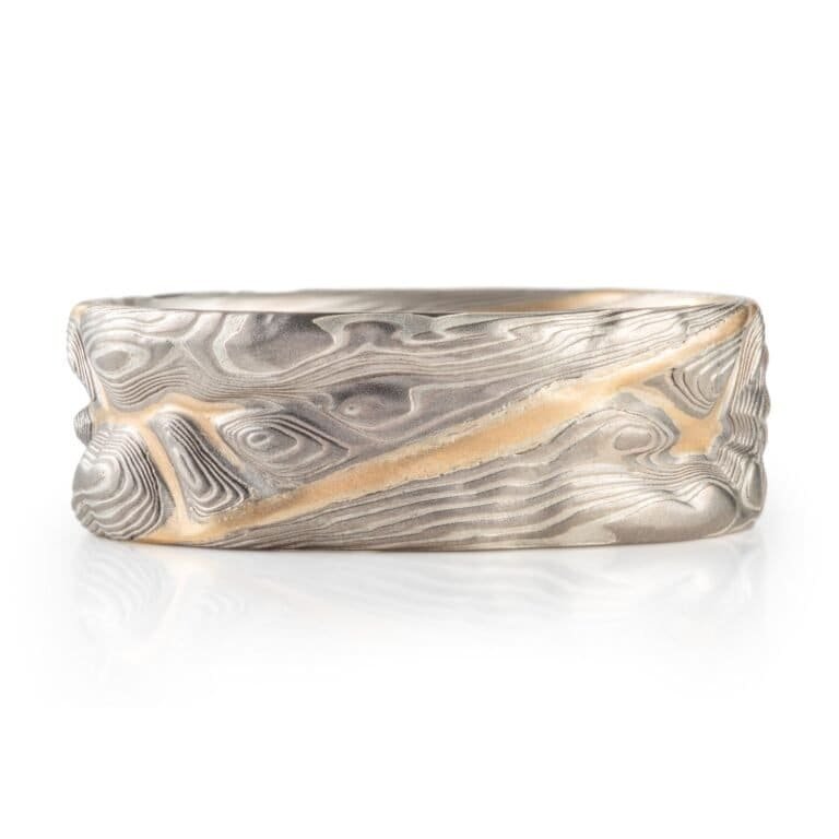 mokume gane pattern ring, topographical style patterning, mostly silver with a yellow gold stratum layer peeking out from under other layers