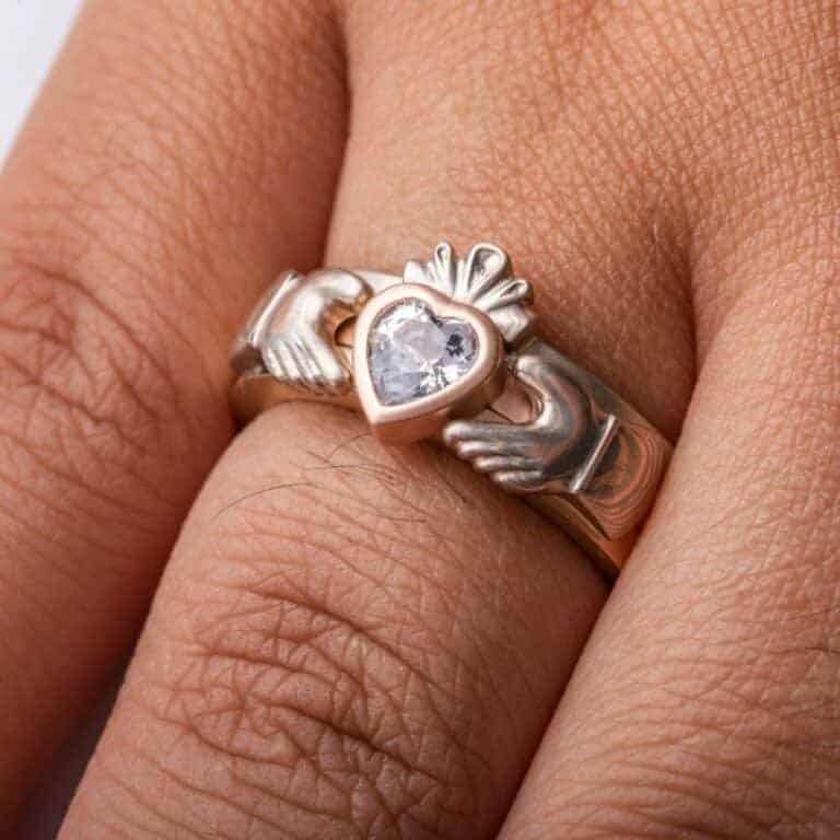 custom made three part claddagh ring, with mokume hands holding a white sapphire heart shaped stone, with a mokume crown on top of the stone