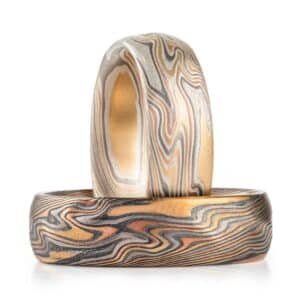 set of matching mokume patterned rings, made with the same metals, but one looks overall lighter because the silver layers are not oxidized, the other has oxidized silver