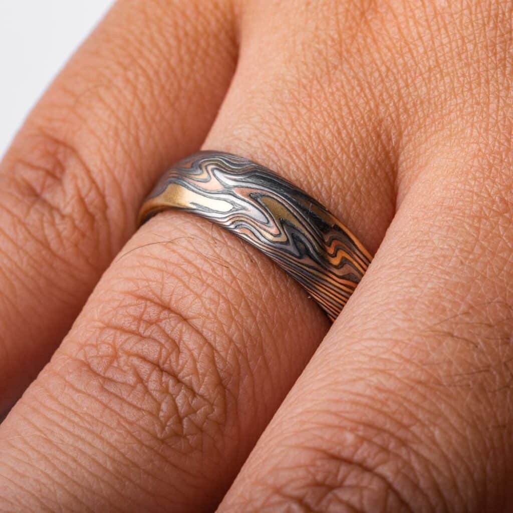 mokume twist pattern ring, made with red and yellow gold, palladium and oxidized silver, with some added texture