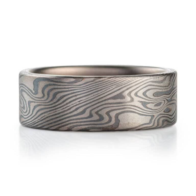 wide flat profiled ring, made in mokume twist pattern with alternating layers of palladium and oxidized silver