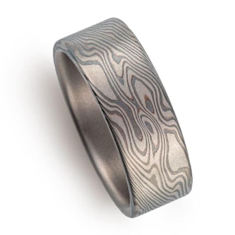 wide flat profiled ring, made in mokume twist pattern with alternating layers of palladium and oxidized silver