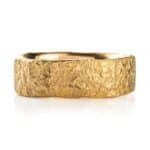 yellow gold band with a stone like texture all over