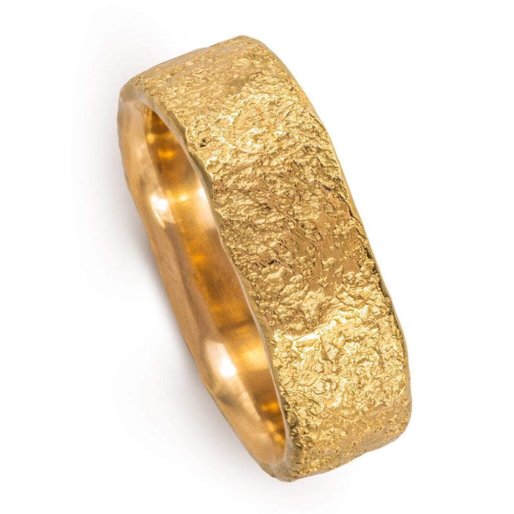 yellow gold band with a stone like texture all over