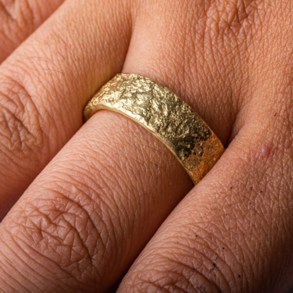 yellow gold band with a stone like texture all over