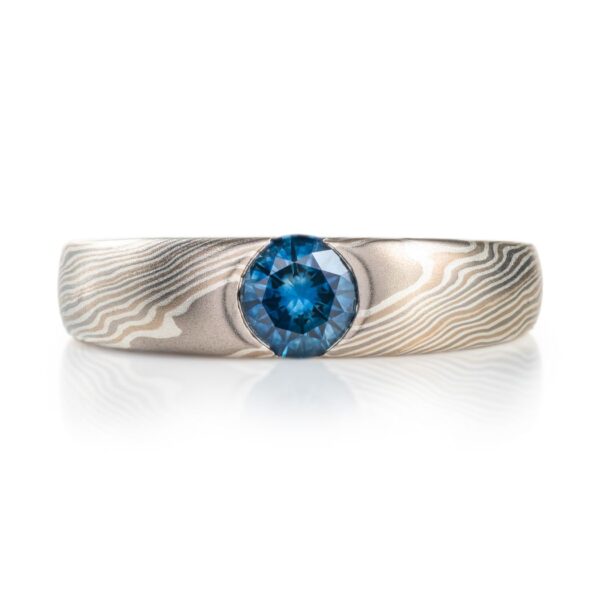 cathedral style ring, slightly thicker towards the top and tapered to the underside, with a round blue stone set into the top