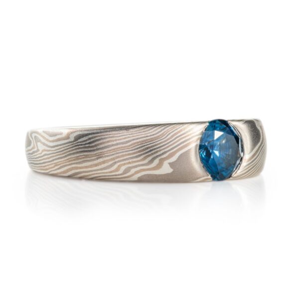 cathedral style ring, slightly thicker towards the top and tapered to the underside, with a round blue stone set into the top