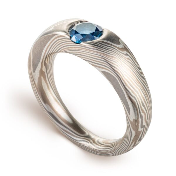 cathedral style ring, slightly thicker towards the top and tapered to the underside, with a round blue stone set into the top