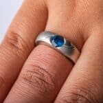 cathedral style ring, slightly thicker towards the top and tapered to the underside, with a round blue stone set into the top