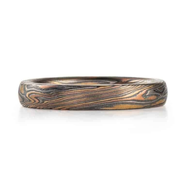 twisted pattern mokume ring, overall darker looking, made with yellow and red golds and palladium and oxidized silver