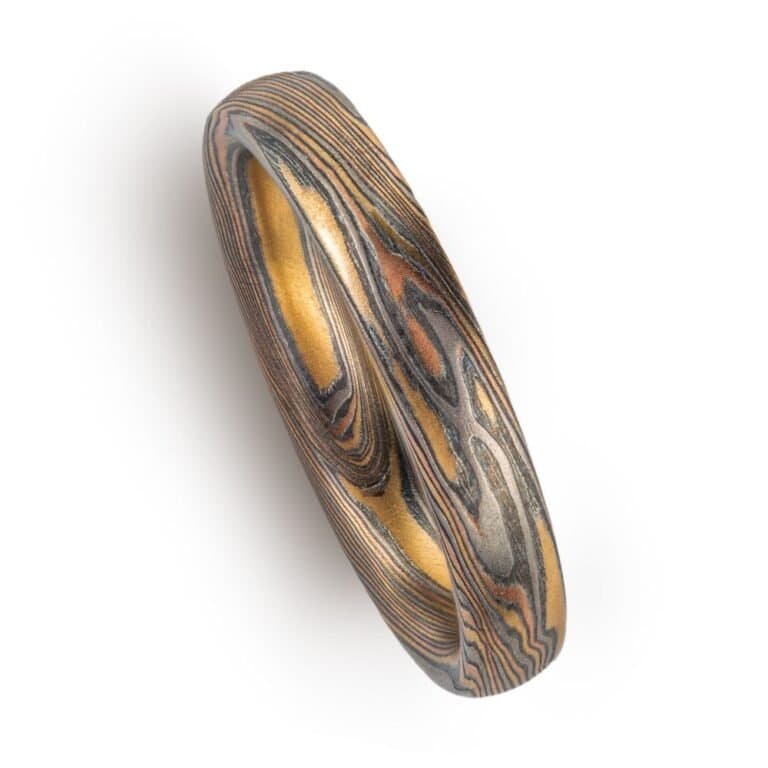 twisted pattern mokume ring, overall darker looking, made with yellow and red golds and palladium and oxidized silver