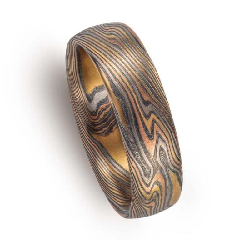 twisted pattern mokume ring, overall darker looking, made with yellow and red golds and palladium and oxidized silver