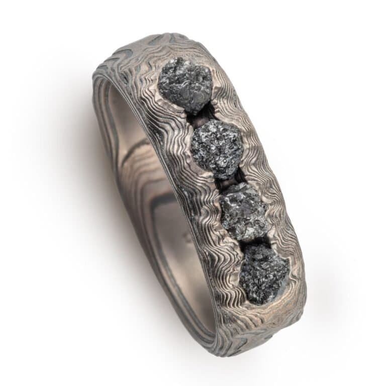 RAW BLACK DIAMONDS in layers of Mokume Gane metal that has striped and lines and ripples. looks like layered earth