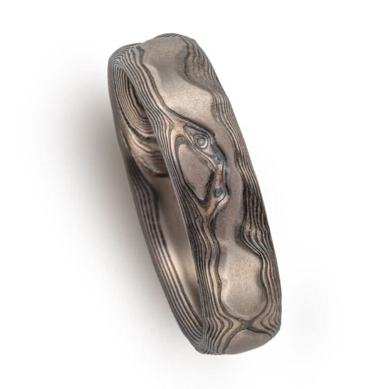 textured mokume ring made to look like rock formation, overall dark gray palette