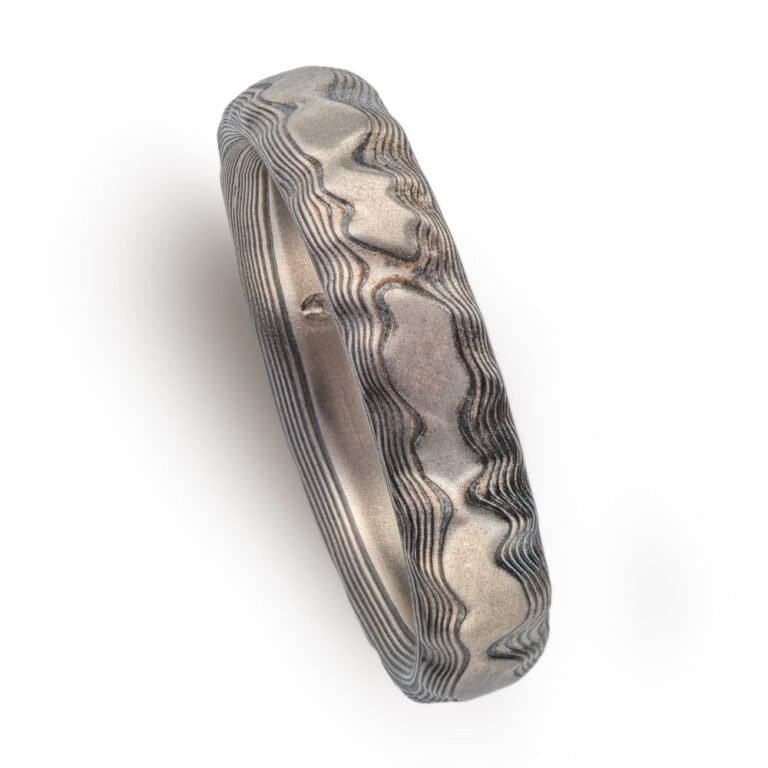 textured mokume ring made to look like rock formation, overall dark gray palette