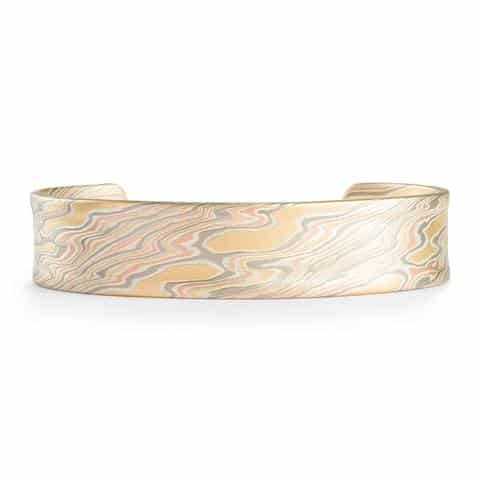 The Twist Mokume Gane bracelet features the Firestorm palette with 14kt red & yellow gold, palladium, and sterling silver.