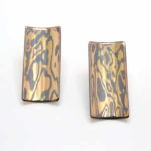 Handmade post earrings in 14k yellow gold and oxidized silver mokume gane with a satin finish, measuring 1" long and 1/2" wide.