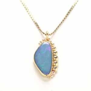 Australian Opal set in textured 18kt yellow gold with 16" chain.
