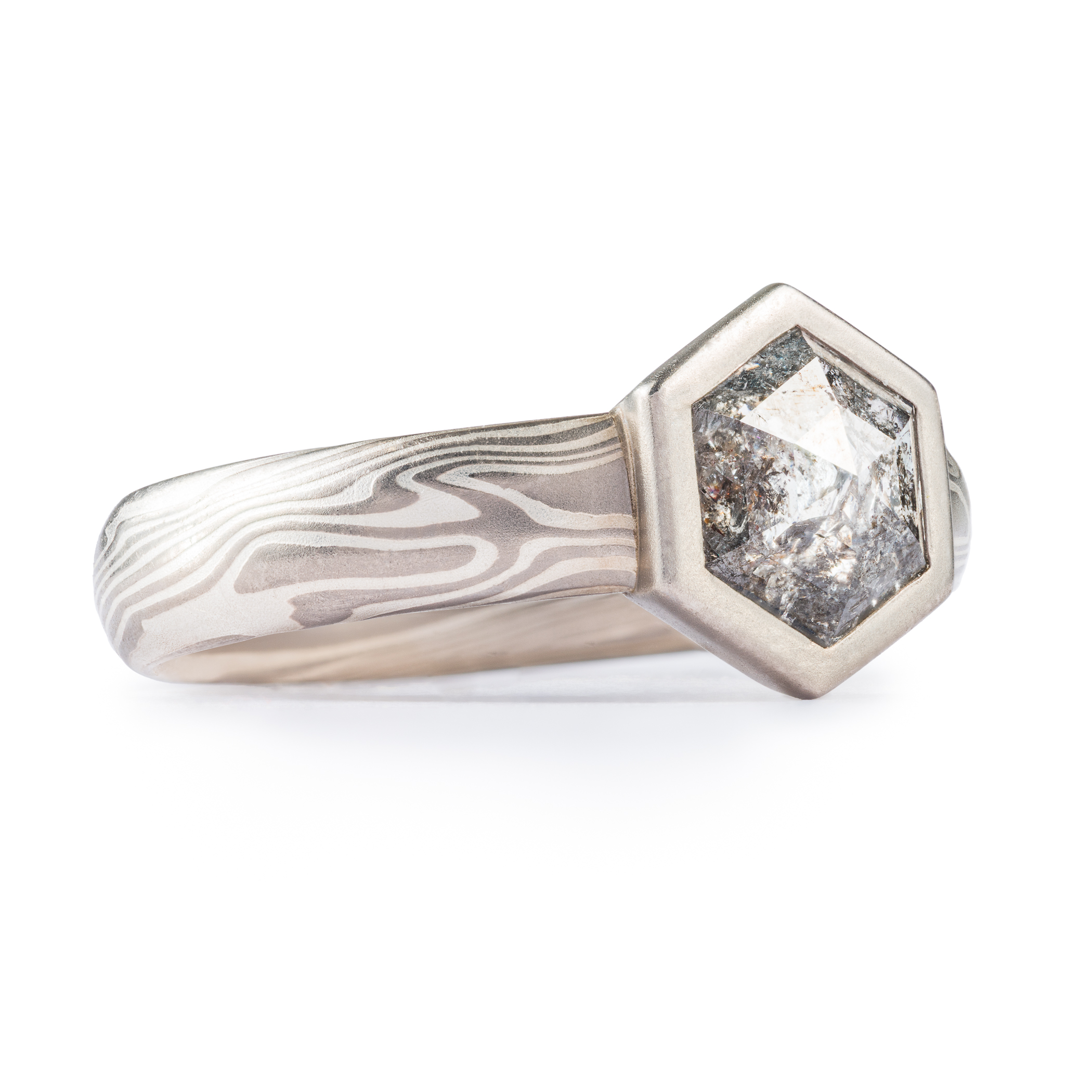 salt and pepper diamond in hexagon cut with hexagon bezel in white gold mokume gane.