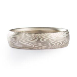 A light and elegant Mokume Gane ring in Twist pattern and Ash Palette has a low dome profile and silvery palette with gentle twisting patterning resembling fog rolling in over a chilly New England morning.