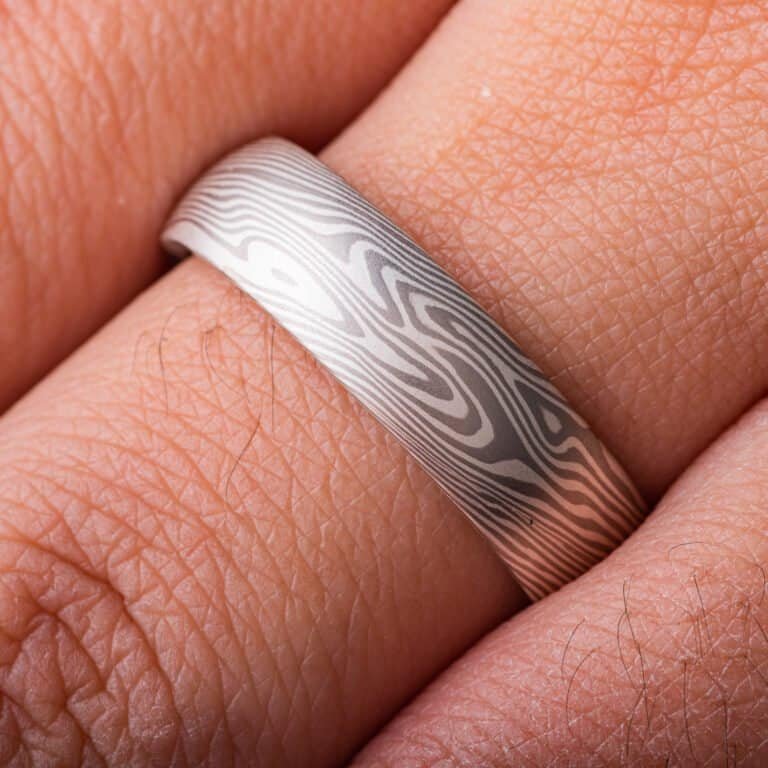 A light and elegant Mokume Gane ring in Twist pattern and Ash Palette has a low dome profile and silvery palette with gentle twisting patterning resembling fog rolling in over a chilly New England morning.