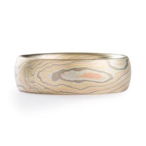 elegant, clean mokume gane band with domed profile, made in a twisted pattern with diagonal lines running across, with red and yellow gold, palladium, and etched silver