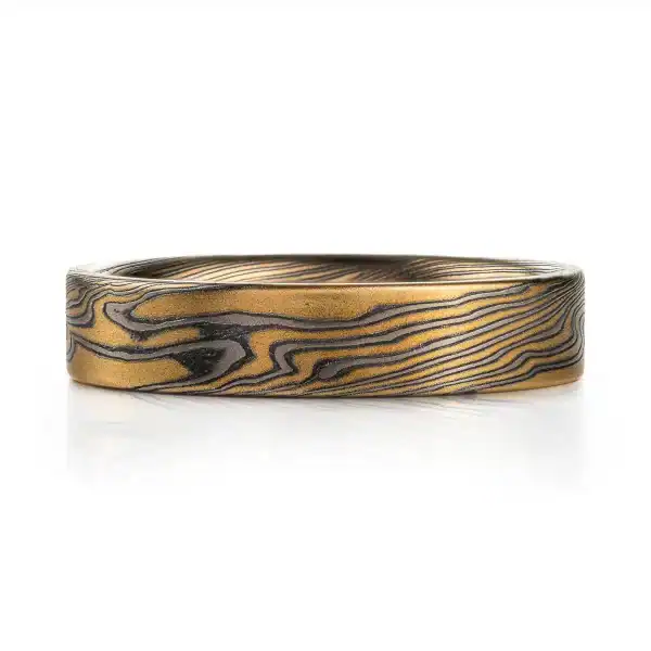 rustic gold mokume gane band with a flat profile ring, high contrast with oxidized silver