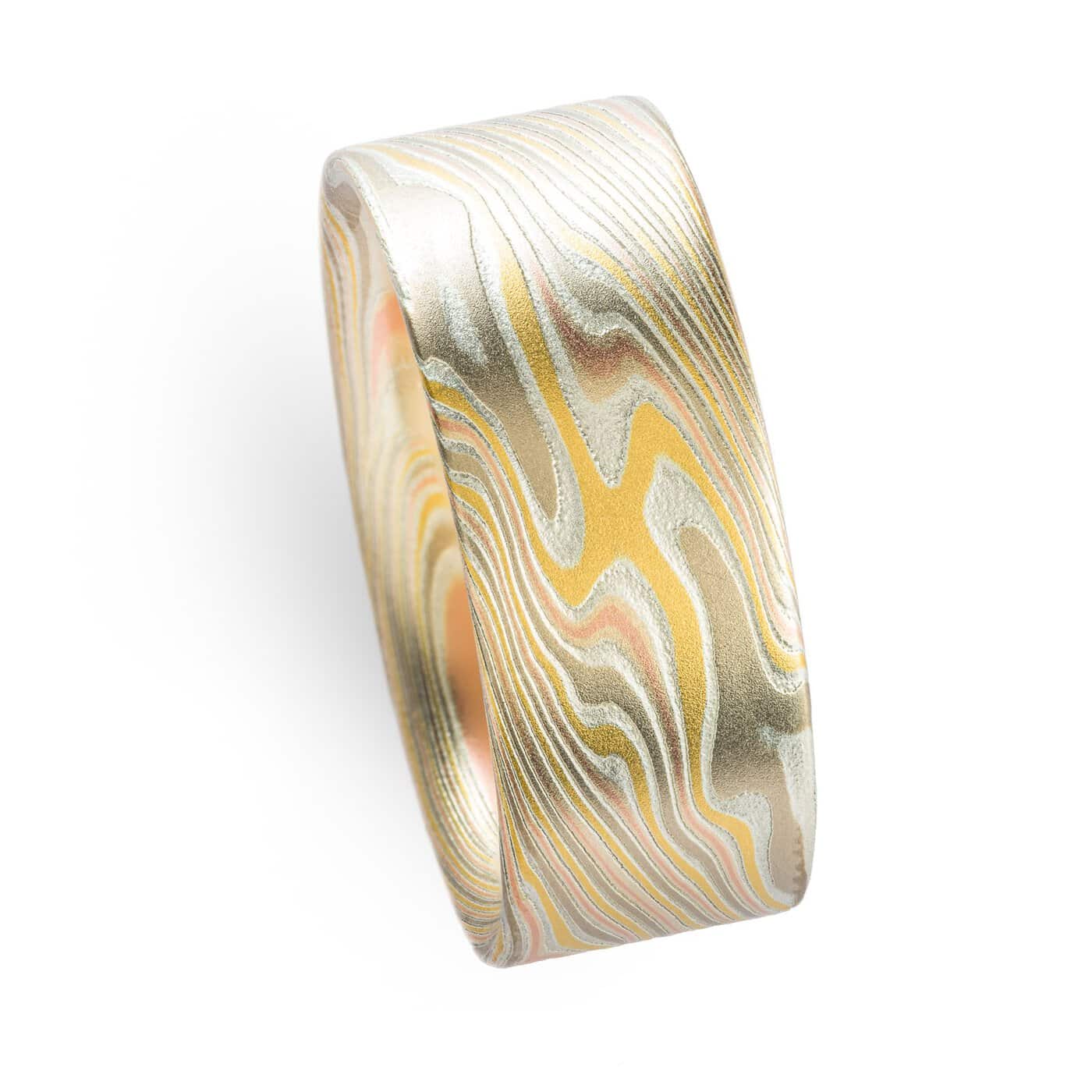 wide mokume gane twist patterned ring with a flat profile, ring is made with layers of red and yellow gold, palladium and etched silver