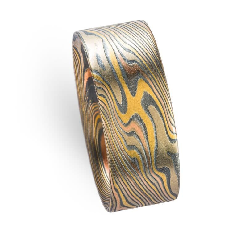 wide mokume gane twist patterned ring with a flat profile, ring is made with layers of red and yellow gold, palladium and oxidized silver