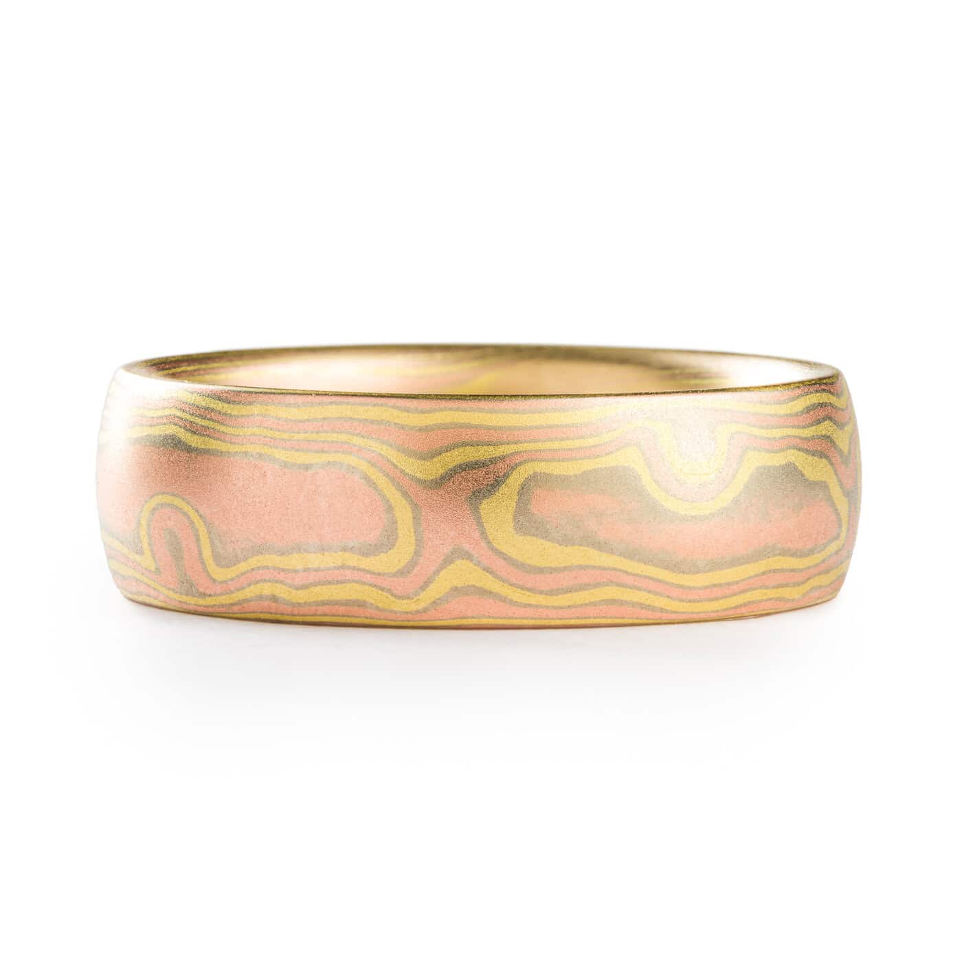 All gold mokume gane ring made in woodgrain pattern, with layers of red gold and yellow gold, and thin layers of white gold in between.