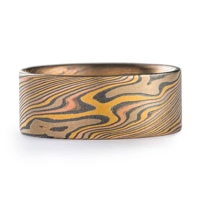 wide mokume gane twist patterned ring with a flat profile, ring is made with layers of red and yellow gold, palladium and oxidized silver